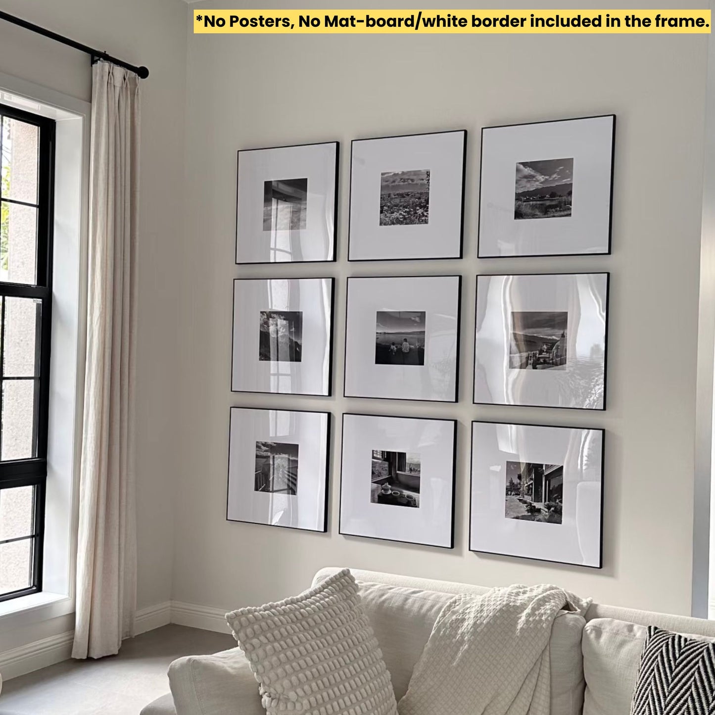 Wall with framed black and white pictures above a sofa in a room with a window and curtain.